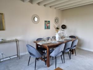 a dining room with a wooden table and blue chairs at Au Mont Chez Nous # Jacuzzi & Sauna # in Pontorson