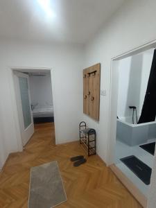 a white room with a mirror and a wooden floor at MiYo STAY in Žitkovac