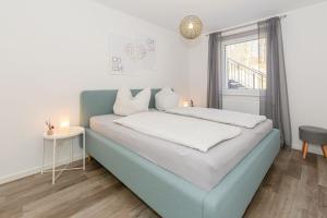 a bedroom with a blue bed and a window at Haus Waldidyll, Vergissmeinnicht - Bade- & Saunawelt täglich inklusive in Ostseebad Sellin