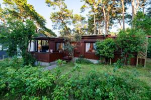 a house in the woods with trees at Ferienhaus am Strand 92 - Bade- & Saunawelt täglich inklusive in Baabe