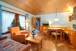 a living room with a kitchen and a dining room at Ferienhaus am Strand 92 - Bade- & Saunawelt täglich inklusive in Baabe