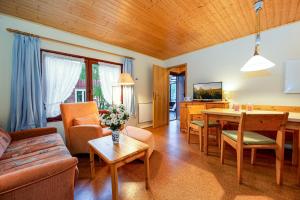 a living room with a couch and a table at Ferienhaus am Strand 92 - Bade- & Saunawelt täglich inklusive in Baabe