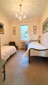 a bedroom with two beds and a chandelier at Residenza Rosmarino CASA GUARNONE in Mornico Losana +62 photos