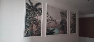 a wall with three paintings of plants on it at The bhandhavghad regency in Udaipur