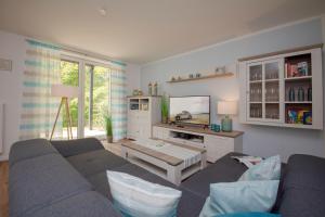 a living room with a couch and a table at Haus Waldidyll, Küstenflair - Bade- & Saunawelt täglich inklusive in Ostseebad Sellin