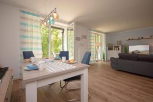a living room with a table and a couch at Haus Waldidyll, Küstenflair - Bade- & Saunawelt täglich inklusive in Ostseebad Sellin