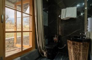 a bathroom with a toilet and a window at The Yellowstone in Bīr +66 photos