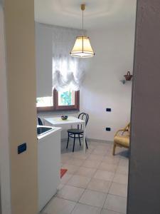 d'une cuisine avec un évier et une table avec une fenêtre. dans l'établissement Rosa's House - zona ospedaliera, à Cagliari