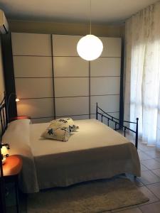 a bedroom with a large bed with a lamp at Rosa's House - zona ospedaliera in Cagliari