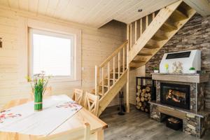 a living room with a fireplace and stairs at Orawska Sielanka in Roztoki
