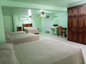 a bedroom with two beds and a table and a desk at Freedom Shores "La Gringa" Hotel - Universally Designed in Isla Aguada
