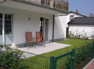 two chairs sitting on a porch of a house at Ostseebrise - Bade- & Saunawelt täglich inklusive in Thiessow