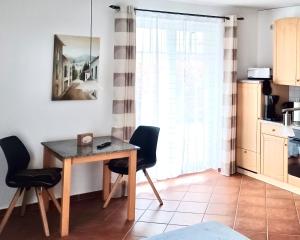 a kitchen with a table and chairs in a room at Ostseebrise - Bade- & Saunawelt täglich inklusive in Thiessow