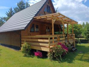 a large wooden cabin with a gambrel roof at Domek Hanka in Biskupice +11 photos