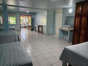 a room with two beds and a table and a television at Freedom Shores "La Gringa" Hotel - Universally Designed in Isla Aguada