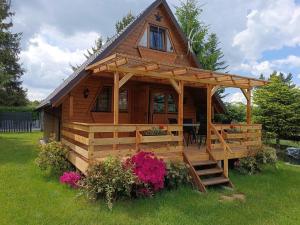 a large wooden cabin with a staircase in the grass at Domek Hanka in Biskupice