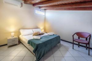 a bedroom with a bed and a red chair at Busacca Suite in Scicli