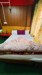 a bedroom with a bed with a wooden head board at Tenzing Homestay in Kalimpong