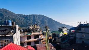 a group of buildings with mountains in the background at Tenzing Homestay in Kalimpong