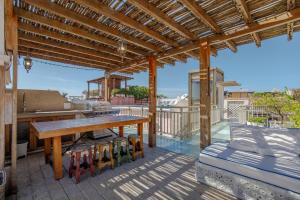 a patio with a wooden table and a bench on a deck at Casa Stella - Authentic Luxury Rooftop Pool in Cartagena de Indias