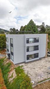 een wit gebouw bovenop een veld bij Apartamento de lujo a 3 minutos del Aeropuerto JMC 101 in Rionegro