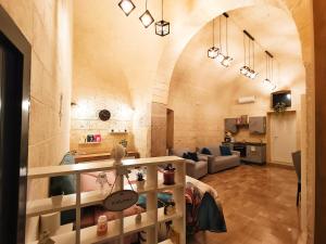 a large living room with a large stone wall at Dimora Pietra e Mare Trani in Trani