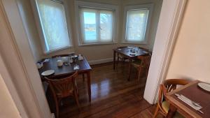 a dining room with two tables and two windows at Hotel Casa Woerner - Caja los Andes in Valdivia