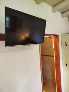 a flat screen tv hanging on a wall at Cabañas Entre Verde in Los Hornillos