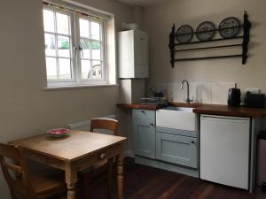 eine Küche mit einem Tisch, einem Waschbecken und einem Fenster in der Unterkunft North Street annexe in Ilminster