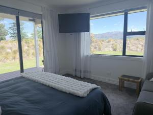 a bedroom with a bed with a large window at Guesthouse B in Twizel