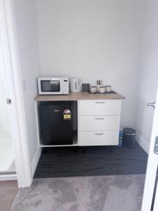 a small kitchen with a microwave and a dishwasher at Guesthouse B in Twizel