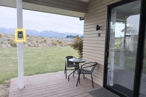 a patio with two chairs and a table on a porch at Guesthouse B in Twizel