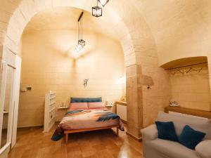 a bedroom with a bed and a couch in a room at Dimora Pietra e Mare Trani in Trani