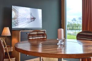 a dining room with a table and a tv at IDAHO - Deep in Süderstapel