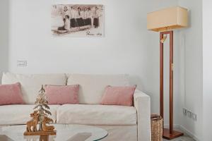 a living room with a white couch with pink pillows at Apartment Maira in Chiavenna