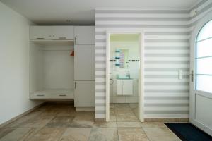 a bathroom with white walls and white cabinets at Ferienhaus "Stella Olivia" - Bade- & Saunawelt täglich inklusive in Lobbe +33 photos