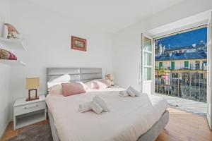 a white bedroom with a large bed and a window at Apartment Maira in Chiavenna +21 photos