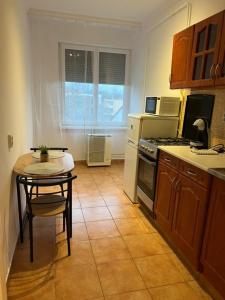 a kitchen with a table and a small table with a table at Greatforest apartman 2 in Debrecen
