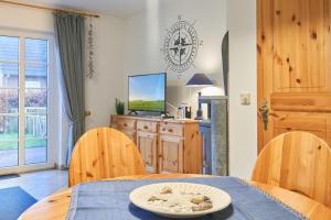 a dining room with a table and a television at Muschelsucher 2 in Nordstrand