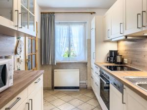 a kitchen with white cabinets and a window at Muschelsucher 2 in Nordstrand