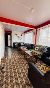a living room with couches and tables in a room at Tenzing Homestay in Kalimpong