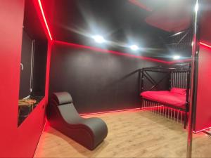 a room with a red lighted room with a red chair at RED Тематичні Апартаменти in Zhytomyr