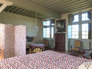 een slaapkamer met een groot bed in een kamer met ramen bij Manoir du Plessis au Bois in Vauciennes