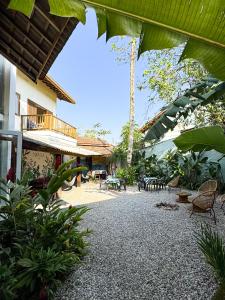 a courtyard of a building with chairs and plants at Marola Hostel in Ubatuba