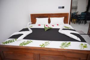 a bedroom with a large bed with flowers on it at Dilithy Paradise in Trincomalee