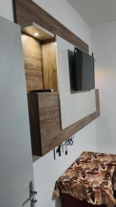 a flat screen tv on a wall in a room at Cantinho aconchegante in Timbó