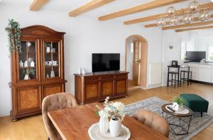 ein Wohnzimmer mit einem Holztisch und einem Fernseher in der Unterkunft MPK Motorsport Apartment in Waldsassen