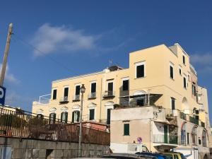 a tall white building with cars parked in front of it at Casa Azzurra in Ischia