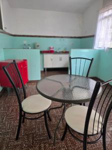 a table and chairs in a room with a kitchen at Casa confortável e central in Poços de Caldas +4 photos