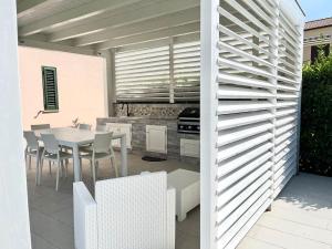 a patio with a table and chairs and a kitchen at Casa Roccella in Buonfornello +19 photos
